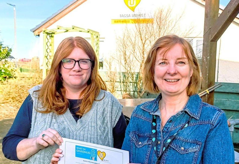 Two women holding a signed charter agreement